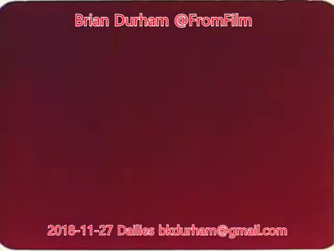 The still features a deep red background with overlaid text. The text includes the names 'Brian Durham' and '@FromFilm,' along with the date '2018-11-27' and an email address. It appears to be a title card or identifier for a film still related to the dailies from that date.