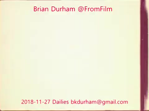 The still features a blank, possibly aged film background with a color gradient. Text overlay includes the name 'Brian Durham,' the handle '@FromFilm,' and the date '2018-11-27 Dailies' alongside an email address. The design focuses on a classic film aesthetic, with a subtle vintage tone.