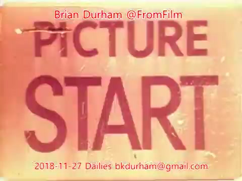 The still features a vintage film marker with the words 'PICTURE START' prominently displayed. The image has a warm, sepia tone, suggesting age, and includes the date '2018-11-27' along with contact information for Brian Durham and the handle '@FromFilm.' The overall aesthetic evokes a classic filmmaking ambiance, reminiscent of past film dailies.