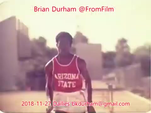 The still features a young man wearing a jersey with 'ARIZONA STATE' written on it, suggesting he is likely an athlete at Arizona State University. The background appears to show an outdoor setting, possibly a track or athletic facility. The colors are warm and slightly faded, characteristic of 16mm film. Text overlays include the name 'Brian Durham,' a timestamp '2018-11-27,' and a contact email for further inquiries.