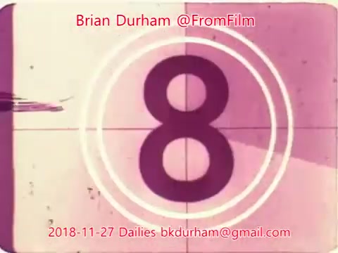 The still features a vintage film countdown with the number '8' prominently displayed. The design includes circles and a faded color palette typical of 16mm film. The date '2018-11-27' is noted along with contact information for Brian Durham, suggesting it is part of film dailies from that date. The aesthetic reflects classic film visuals.
