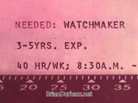 The still features a job posting with the heading 'NEEDED: WATCHMAKER.' It specifies a requirement of 3-5 years of experience, a work schedule of 40 hours per week, and hours from 8:30 A.M. onward. The background has a pinkish tint, giving it a vintage look typical of the 1970s.