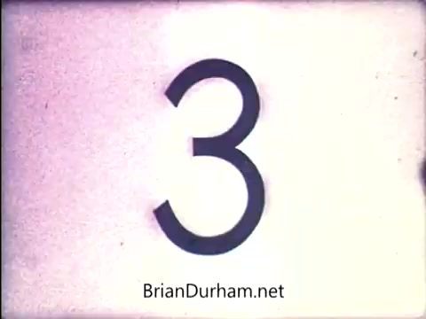 The still features a large, stylized number '3' against a light background, likely indicating a countdown or part of a sequence in a film or commercial. The aesthetic appears vintage, characteristic of early 1970s film graphic design. The text 'BrianDurham.net' is included at the bottom, possibly referencing the source or creator associated with this material.