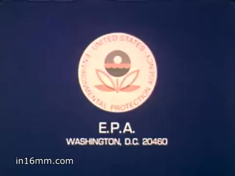 The still features the emblem of the United States Environmental Protection Agency (EPA) against a blue background. The logo displays a stylized image of a plant and water, symbolizing environmental protection. The text indicates the agency's name and location in Washington, D.C. This imagery aligns with the context of raising awareness about solid waste issues in the United States, as highlighted by the voiceover discussing the vast amounts of waste produced annually.