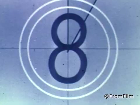 The still portrays a classic film countdown from a 16mm projector, featuring a large, bold number '8' set within concentric white circles. This countdown indicates the final moments before the start of the PSA, which is associated with the National Foundation for the March of Dimes from 1975. The overall aesthetic reflects vintage filmmaking techniques, emphasizing the era's style.