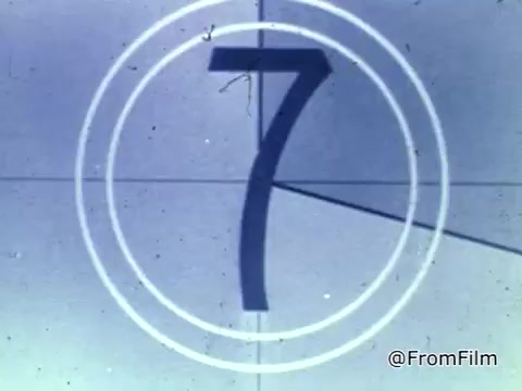 The still features a vintage-style countdown, typical of 16mm film, with the large number '7' prominently displayed in the center. The design includes concentric circles surrounding the number, indicating the countdown process. The color palette appears muted, characteristic of older film stock, and the image suggests a transition into the PSA for the National Foundation of the March of Dimes from 1975.