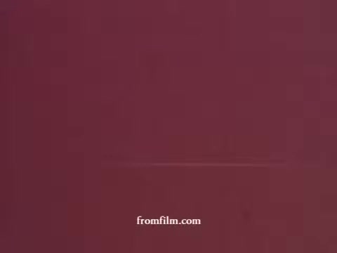 The still from the 'Empire Card commercial - 1970's' features a simple, solid background with a deep maroon color, typical of the era's aesthetic. The composition seems to focus on minimalism, likely emphasizing the branding or promotional message of the Empire Card from M&T Bank. The image bears the characteristics of a 16mm print, suggesting graininess or texture.