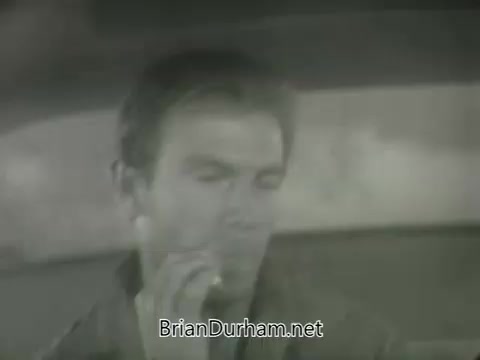 The still from the 'ABC Fall 1963 season promos' features a man sitting in a car, appearing contemplative or pensive. The scene is monochromatic, contributing to a vintage aesthetic typical of the era. The man's expression hints at a narrative or emotional depth, likely related to the themes promoted in the season.