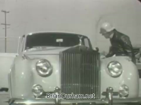 The still features a vintage car, possibly a Rolls-Royce, with a uniformed figure leaning over the front. The image is black and white, reflecting the style and aesthetics of the early 1960s. The background suggests an outdoor setting, likely a promotional shoot for the ABC network. The overall tone conveys a sense of nostalgia, characteristic of that era's television promotions.