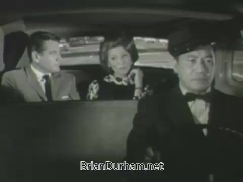 The still features three individuals inside a car: a man in a suit and a woman in a stylish dress seated in the back, and a driver in uniform at the front. The setting has a classic, mid-20th century feel, suggesting a scene from a promotional piece for ABC's 1963 fall season. The expressions and positions of the characters hint at a moment of conversation or interaction, typical of promotional narratives meant to engage viewers.