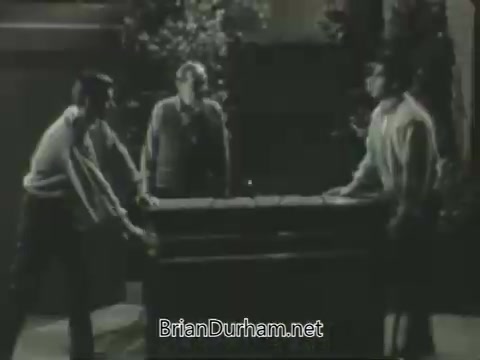 The still captures three men, two lifting a large object between them while a third stands next to them, observing. The scene has a vintage, monochrome aesthetic typical of the 1963 era, reflecting a casual or humorous moment. The setting appears relaxed, likely depicting a lighthearted interaction as part of the promotional content for ABC's fall season.