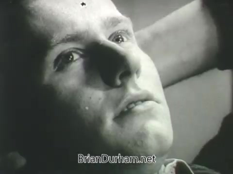 The still from the 1968 US Army ROTC commercial shows a young man lying back with a contemplative expression. His eyes are focused upwards, suggesting introspection. The lighting highlights his facial features, conveying a serious or reflective mood. The overall tone is reminiscent of recruitment themes aimed at highlighting personal growth and national service.