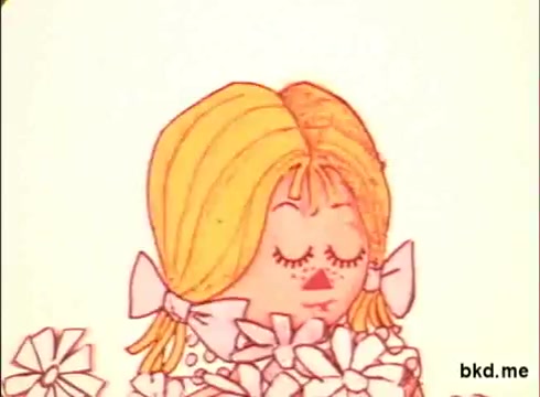The still depicts a colorful animated character, likely a young girl, with blonde hair and bows, surrounded by white flowers. The style is characteristic of 1970s animation, featuring bold colors and simple, whimsical designs. The character appears serene, suggesting a lighthearted or cheerful theme typical of advertisements from that era.