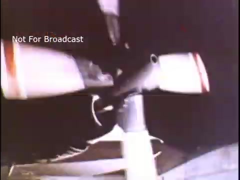 The still features a close-up view of a boat's motor or propeller, highlighting the mechanical components in action. It conveys a sense of focus on safety and the operational aspects of marine equipment, typical of a 1970s US Coast Guard public service announcement. The visual style aligns with the vintage aesthetic of that era's film production, emphasizing reliability and preparedness.