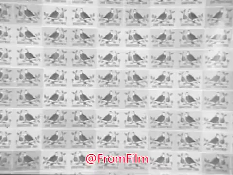 The still from the 1968 Christmas Seals PSA featuring James Garner shows a background pattern of multiple birds, likely stylized or illustrated, sitting on branches with leaves. The design is repetitive and monochromatic, contributing to a festive and cheerful vibe appropriate for the holiday season. Garner's message likely revolves around the spirit of giving and the importance of supporting charitable causes during the holidays.