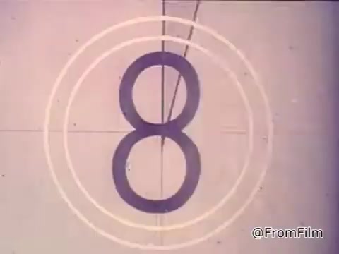 The still shows a classic countdown graphic from a 16mm film, indicating a transition in the ad for Nestlé Semi-Sweet Chocolate Chips from the 1970s. Accompanying the visual, a girl's voiceover highlights the appeal of freshly baked Toll House cookies, emphasizing the key ingredient, Nestlé's Semi-Sweet Morsels, and the unique recipe found on the package. The ad underscores that Toll House cookies are a special homemade treat that can't be bought pre-made.