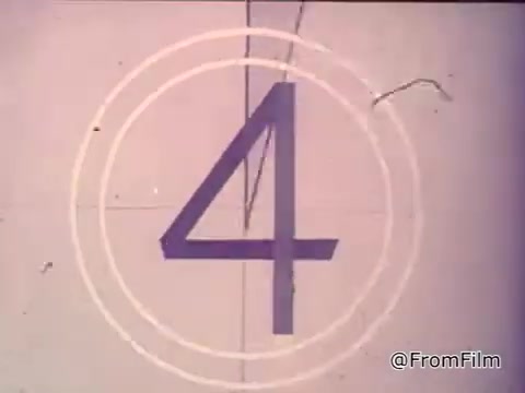 The still features the number '4' surrounded by concentric circles, indicative of a classic film countdown. The context is a vintage advertisement for Nestlé Semi-Sweet Chocolate Chips from the 1970s. A girl reads from a package, promoting the idea that every good cook knows the secret to delicious Toll House cookies lies in using Nestlé's morsels. The voiceover highlights their extra chocolaty and chewy nature, referencing the recipe included on the package and reaffirms that Toll House cookies can’t be bought, only made at home.