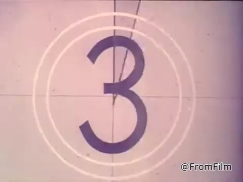 The still features a countdown for a film, indicating it's nearing the start of a scene. The context revolves around a girl reading from a package of Nestlé semi-sweet chocolate chips, promoting the recipe for Toll House Cookies. The voiceover emphasizes the quality and appeal of freshly baked cookies made with Nestlé morsels. The overall tone suggests warmth and nostalgia for home baking in the 1970s.