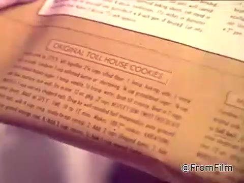 The still features a girl holding a package of Nestlé semi-sweet chocolate chips, specifically highlighting the 'Original Toll House Cookies' recipe. The text on the package emphasizes the cookie's homemade appeal and the key ingredient, Nestlé's semi-sweet morsels, while a voiceover notes the cookies are extra chocolaty and chewy. The message stresses that these cookies can't be bought, reinforcing their unique homemade quality.