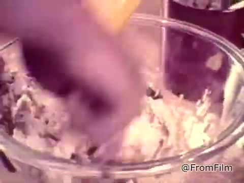 The still captures a close-up of a hand mixing ingredients in a glass bowl, likely preparing cookie dough. The scene ties into the 1970s Nestlé advertisement promoting their Semi-Sweet Chocolate Morsels for making Toll House cookies. The voiceover emphasizes the joy of baking homemade cookies, highlighting the product's key role in achieving that classic taste. The overall feel is nostalgic and homey, reflecting the era's focus on fresh, homemade treats.