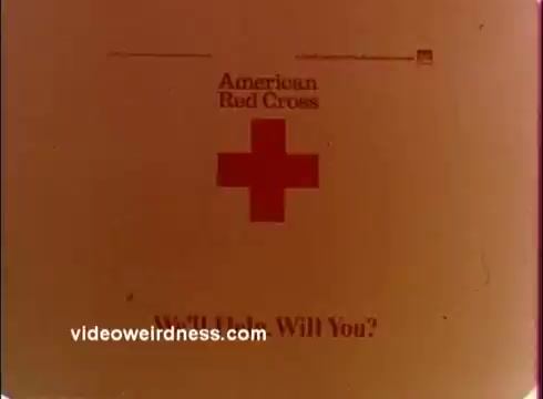 The still features a faded and slightly degraded image from a 16mm print of a 1970s Red Cross PSA. The central focus is the Red Cross emblem, accompanied by the text 'American Bad Cross' and the phrase 'We'll Help, Will You?' The color has a warm, nostalgic tone typical of the era, suggesting a call to action for viewer support.
