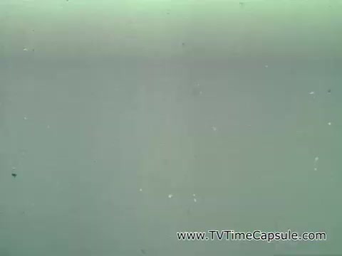 The still from the 'Camp Fire Girls commercial - 1960's' features a simple, unobtrusive background, likely with remnants of film grain and dust typical of older 16mm footage. Patrice Munsel appears at the start, introducing the Camp Fire Girls, emphasizing inclusivity with references to various roles like mothers, businesswomen, and artists involved in the organization. The commercial aims to convey the diversity and community spirit of the Camp Fire Girls program.