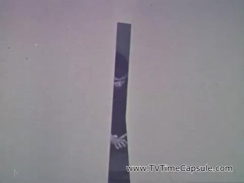 The still from the 'Camp Fire Girls' commercial shows a narrow vertical strip of a scene, suggesting a playful or intriguing composition. Patrice Munsel, the speaker, is describing the diverse membership of Camp Fire Girls, highlighting the inclusion of girls, boys, mothers, and various professionals as group leaders. The image likely aims to convey a sense of community and involvement among varied individuals, reflecting the organization's values of inclusivity and teamwork.