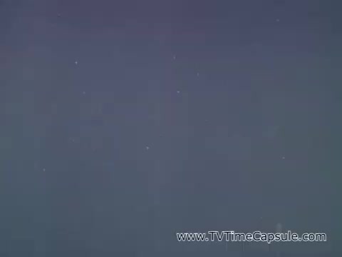 The still from the Camp Fire Girls commercial features a simple background, likely indicating a serene or natural setting. The narration by Patrice Munsel introduces the Camp Fire Girls, highlighting the diversity of participants, including girls and boys from various backgrounds, as well as adult leaders. The focus is on community involvement and the supportive structure of the organization. The visual style is characteristic of 1960s commercials, emphasizing inclusivity and the value of group activities.