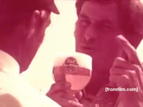 The still features a man animatedly discussing with another individual while holding a Pabst Beer glass. The vibrant colors and retro style capture the spirit of 1970s advertisements. The focus is on the beer and the dialogue, emphasizing a conversational and promotional tone typical of that era's commercials. The scene highlights the relaxed atmosphere often associated with enjoying Pabst Beer.