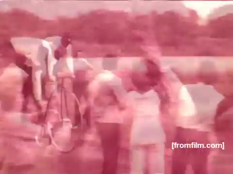 The still from the 'Pabst Beer Commercials - 1970's' features a vibrant outdoor scene with individuals engaging in social activities, likely enjoying leisure time together. The image has a nostalgic color palette characteristic of 1970s film, capturing a lively atmosphere that evokes the spirit of carefree moments associated with beer commercials from that era.