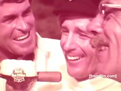The still from the 1970s Pabst Beer commercials features three men joyfully laughing and sharing a moment together. One man is holding a Pabst beer, emphasizing camaraderie and celebration. The warm tones of the image enhance a nostalgic and cheerful atmosphere typical of that era's advertisements.