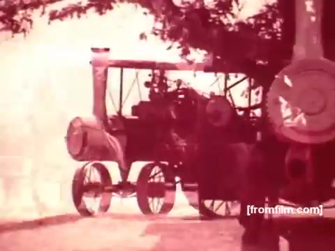 The still features a vintage steam-powered vehicle, likely a tractor or engine, set against a nostalgic backdrop from the 1970s. The image has a warm, faded color palette characteristic of 16mm film, enhancing its retro feel. This scene likely evokes themes of tradition and craftsmanship, connecting Pabst Beer to a historical American spirit.