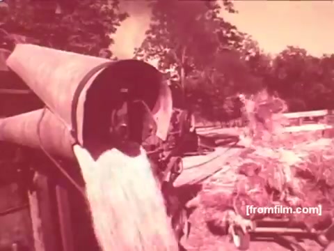 The still from the 'Pabst Beer Commercials - 1970's' shows a grain or malt processing scene. Grain is pouring out of a large funnel onto a pile below, suggesting the brewing process. The overall color tone is tinted, giving it a vintage look characteristic of 16mm film. This imagery evokes the traditional, rustic roots of beer production, aligning with Pabst's brand identity during that era.
