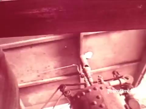 The still from 'Pabst Beer Commercials - 1970's' features an industrial setting, likely related to brewing or beer production. The image showcases machinery components, possibly indicating the beer-making process. The warm, reddish tint suggests an aged film quality characteristic of 16mm prints from that era, capturing the vintage feel of the commercials. The focus is on the equipment, hinting at the craftsmanship behind Pabst Beer.