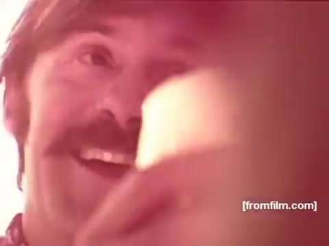 The still from the 16mm Pabst Beer Commercials from the 1970s features a cheerful man with a mustache, smiling as he holds a cup. The warm color palette evokes a nostalgic, upbeat atmosphere typical of advertisements from that era. The focus is on camaraderie and enjoyment, reflecting the casual, social nature of beer consumption.