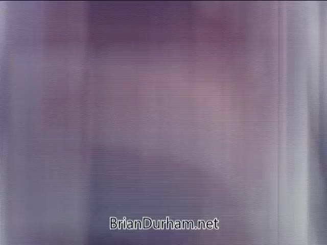 The still from the 'Partial Ronco Spray Gun Commercial - 1960's' captures a segment where colors and shapes appear blurred and distorted, likely due to the age of the film. The image lacks clarity, making it difficult to discern specific details or objects. The reference to Ron's voice suggests an engaging or energetic presentation style typical of commercials from that era. Overall, the still conveys a nostalgic feel, hinting at mid-20th century advertising.