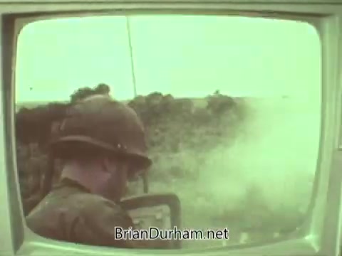The still from the 1960s Episcopal Church PSA depicts a soldier in a helmet, focused on operations amidst a smoky, war-like environment. The image, presented in a muted color palette, highlights the tension of the time and suggests a commentary on the impact of conflict, possibly relating to themes of peace and moral responsibility promoted by the church. The frame appears to be captured from an old television set.