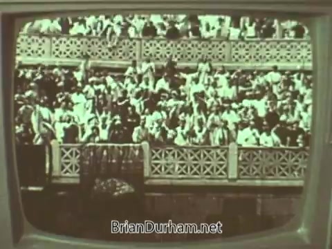 The still features a crowd gathered in a venue, likely a church or outdoor event, with people dressed in 1960s attire. The image is presented within a television frame, suggesting it is part of a public service announcement by the Episcopal Church. The scene conveys a sense of community and participation.