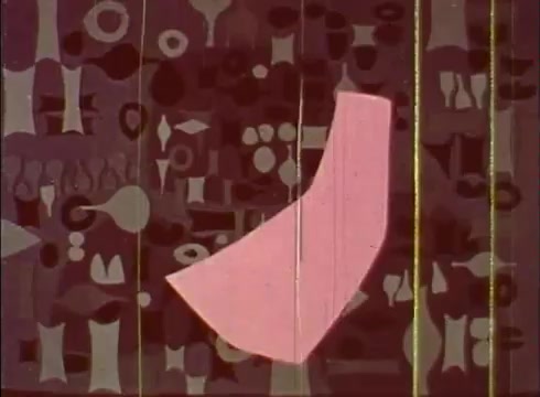 The still features a vibrant, stylized depiction of cellular structures against a rich, patterned backdrop. Central to the image is a large, abstract pink shape that likely represents a part of a cell, surrounded by various geometric forms in muted colors. The overall aesthetic conveys an educational and artistic interpretation of cellular biology, typical of mid-20th-century educational films.