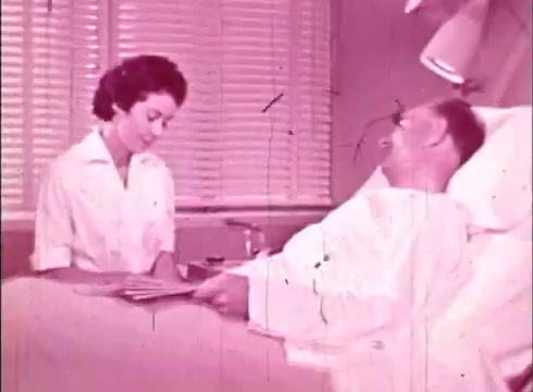 The still features a man in a hospital bed, smiling as he interacts with a female nurse who is seated beside him. The setting appears to be a medical facility, with blinds in the background creating a soft light. The soft pink tint suggests the film's vintage aesthetic, typical of educational films from that era. The nurse is dressed in a classic uniform, and they seem to be engaged in a conversation, possibly discussing health or treatment, aligning with the film's educational theme.