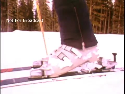 The still features a close-up of a skier's foot in a ski boot, positioned on a pair of skis. The background is snowy, suggesting a mountainous outdoor environment. The image is likely aimed at promoting physical fitness and outdoor activities as part of John Denver's public service announcement for the Presidents Council on Physical Fitness and Sports. The text 'Not For Broadcast' is visible, indicating it's not intended for public airing.