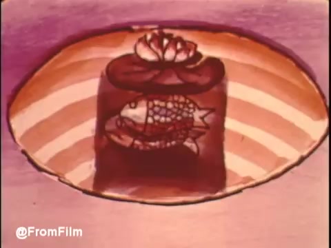 The still features a stylized, animated interpretation of a fish encased in a layered dessert, set against a colorful background. The visual plays with bold shapes and vibrant colors, contributing to the whimsical and surreal vibe characteristic of commercials from that era. This particular scene likely symbolizes comfort and enjoyment, in line with the theme of the Bryant air conditioner’s promotion of gas air conditioning for a pleasant indoor atmosphere.