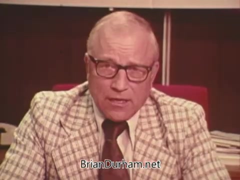 The still features a man in a plaid suit and glasses, speaking directly to the camera in an office setting. He appears serious and engaged, likely addressing concerns related to a political campaign against Issue Six in Ohio, which pertains to nuclear power. The background suggests a formal environment, reinforcing the serious tone of the advertisement.
