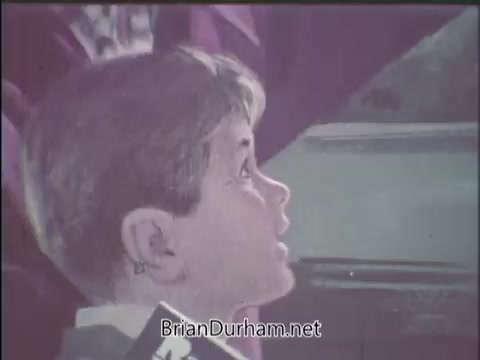 The still features a young boy with short, light-colored hair, gazing upward with a look of curiosity or amazement. His expression suggests he is engaged or captivated by something above him. The background appears to be somewhat blurred, indicating a focus on the boy. The scene likely conveys a message about wildlife or nature, fitting the theme of a National Wildlife Federation PSA.