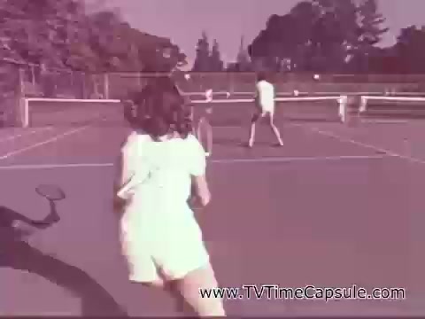 The still features a vintage scene from a 1978 7-Up commercial, showing a tennis game in a park setting. Two players, dressed in white outfits, are engaged in a lively match on a court, with trees in the background. The overall tone is bright and nostalgic, capturing a moment of active play and fun.