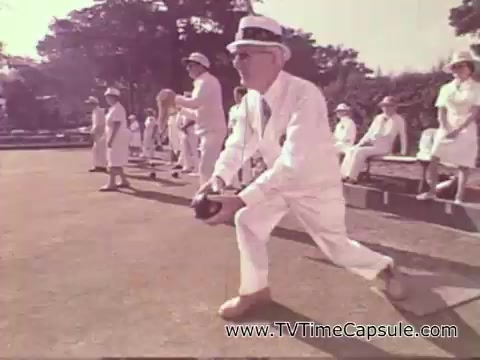 The still features an older man in a white suit and hat, preparing to bowl on a green lawn, surrounded by others in similar attire. The scene conveys a vintage, leisurely atmosphere typical of a 1978 7-Up commercial, highlighting a social gathering focused on lawn bowling. The colors are soft, adding to the nostalgic feel.