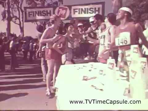 The still features a lively scene from a 1978 7-Up commercial, showcasing a finish line at a running event. Runners in bright athletic gear are gathered around a table displaying 7-Up products after crossing the finish line. The atmosphere is celebratory, with a large 'FINISH' banner overhead, emphasizing the theme of refreshment and achievement.