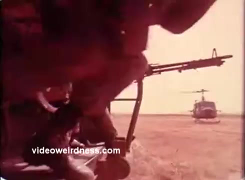 The 16mm still features a scene from the 1970s, highlighting military personnel in a helicopter. The focus is on a soldier’s boots as they prepare to disembark, suggesting readiness and action. In the background, another helicopter is visible, emphasizing the military context. The overall tone conveys seriousness and the support role of employers for guard and reserve members. The color palette is warm, typical of the era's film quality.