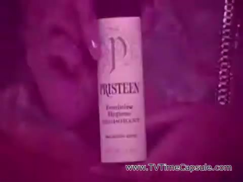 The still features a vintage 16mm print of Pristeen feminine hygiene deodorant spray, prominently displaying the product's label. The background is softly lit, creating a pinkish hue, which adds to the feminine aesthetic typical of the 1970s. The voiceover emphasizes a message of empowerment and freedom, suggesting that Pristeen helps women feel fresh and confident throughout the day. The overall tone of the image reflects the era's marketing focus on liberation and self-expression.