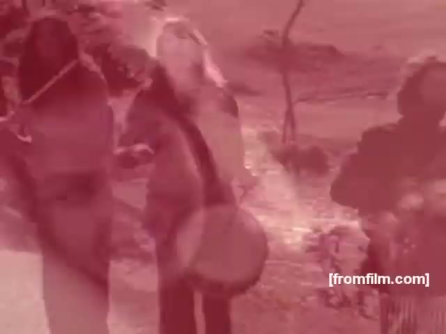 The still appears to feature three individuals engaged in a vibrant outdoor setting, likely promoting a carefree lifestyle associated with the Albany or Richmond cigarette brands. The warm, reddish hue in the image adds a nostalgic and dreamy quality, typical of the 1970s aesthetic, suggesting elements of nature and rhythm, possibly through the use of percussion instruments. This visual style aimed to convey a sense of camaraderie and leisure, reflecting the advertising strategies of that era in promoting smoking.